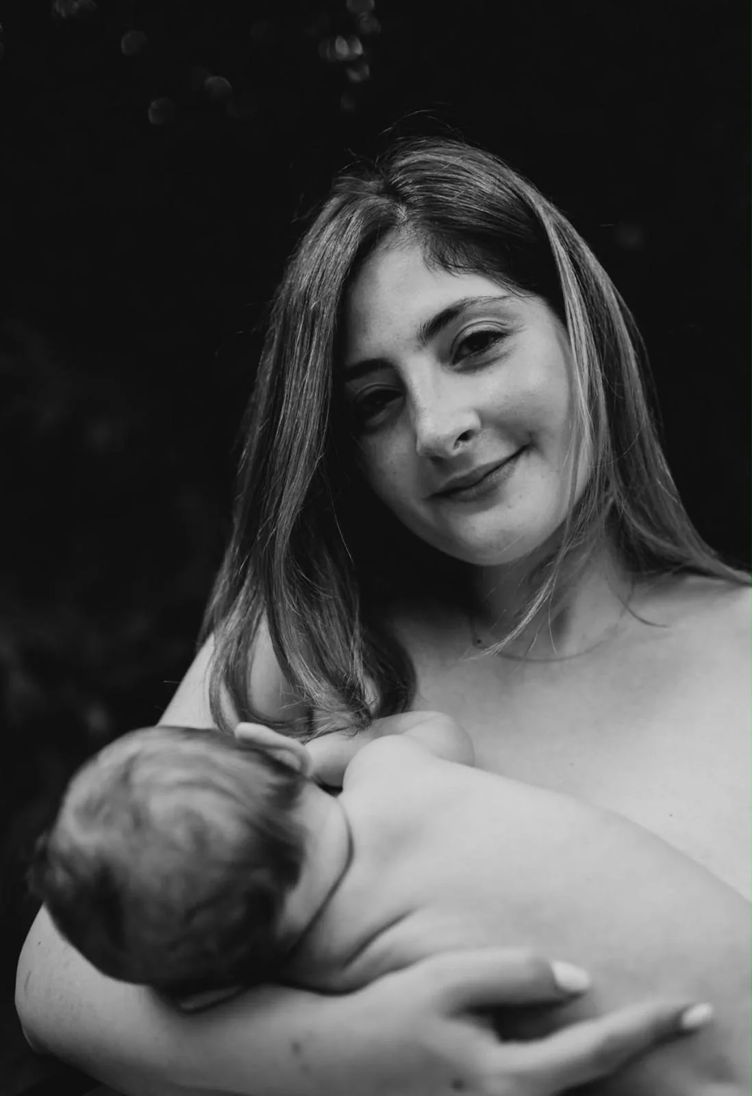 A parent breastfeeding their baby