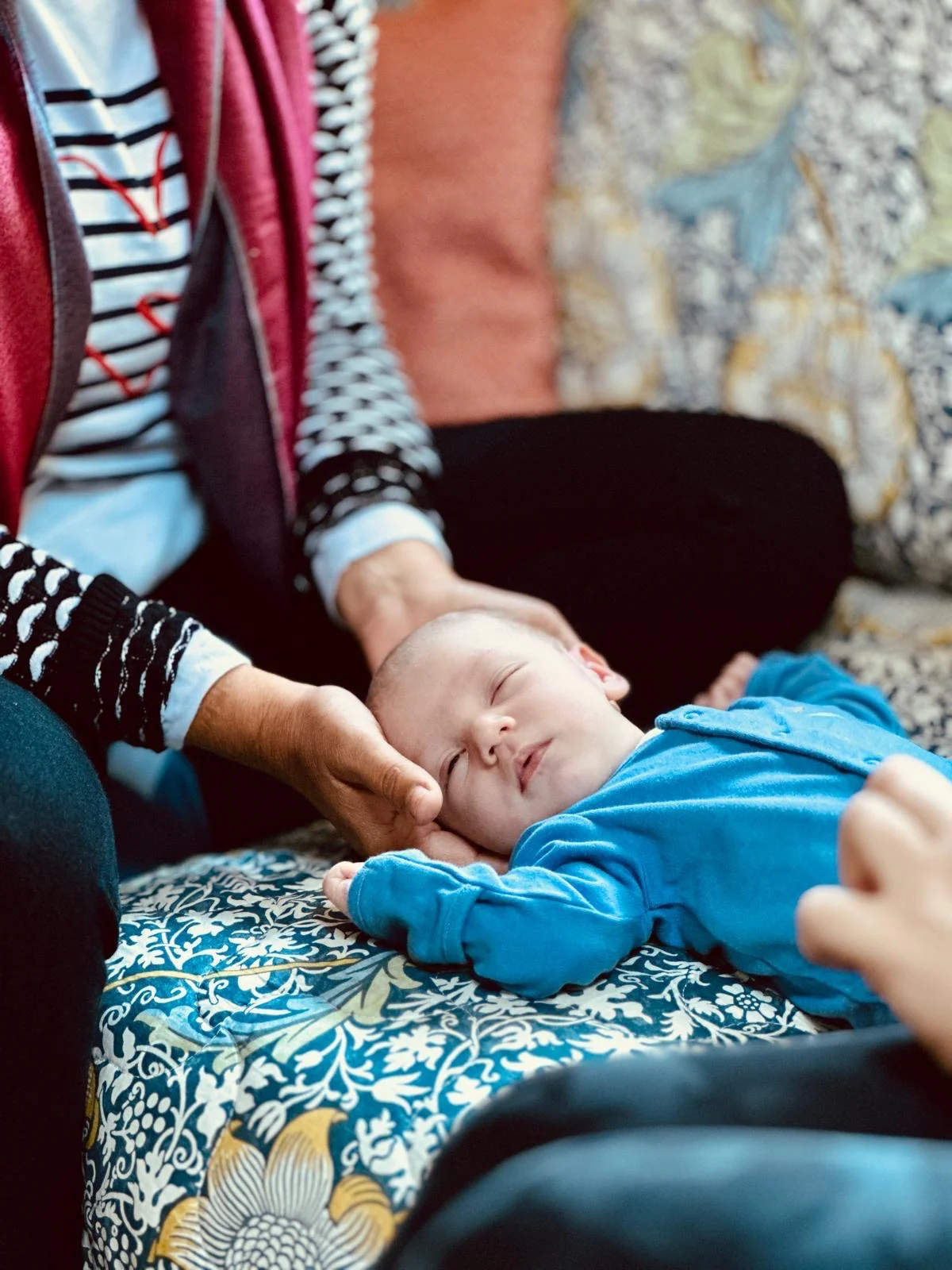 Hands gently supporting a newborn’s head