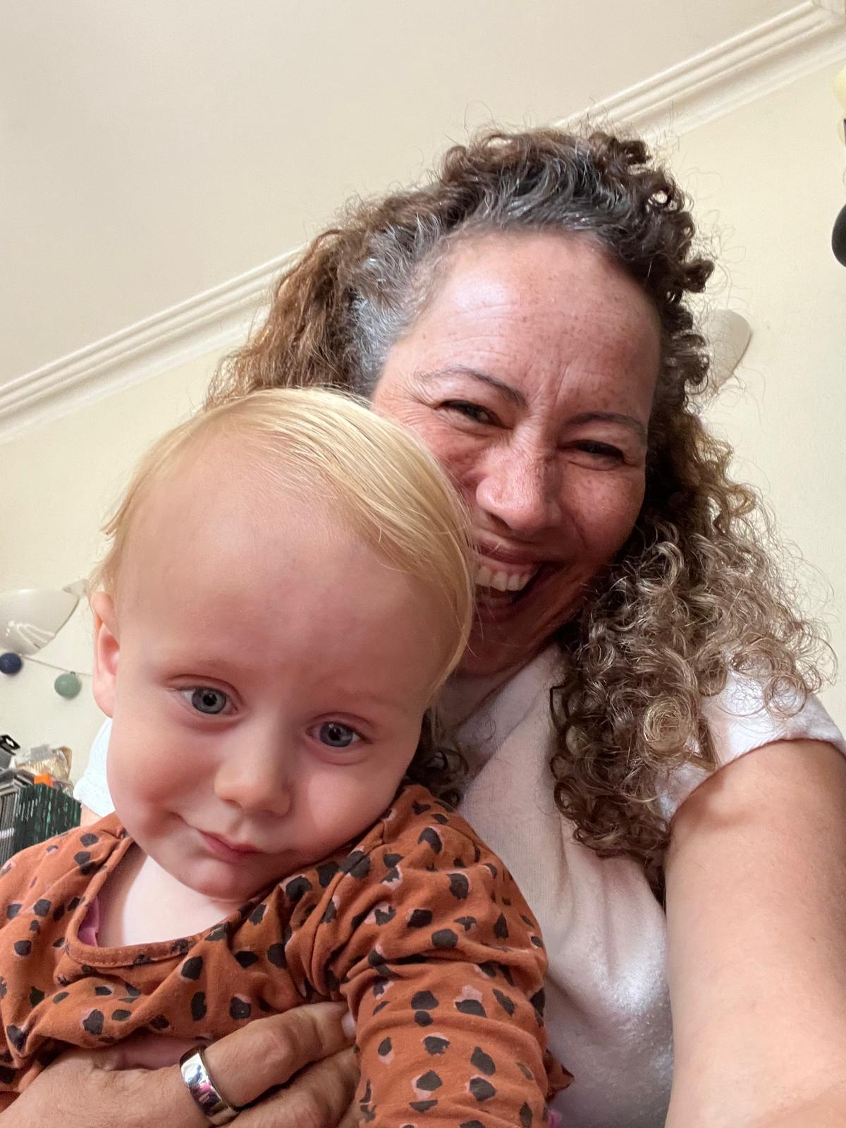 Regina smiling with a young child